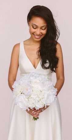 a woman holding a bouquet of white flowers