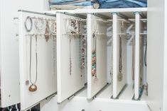 an organized closet with jewelry and necklaces on the door handles, hanging from hooks