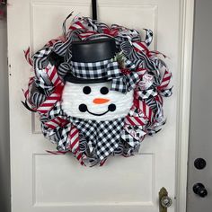 a snowman wreath hanging on the front door