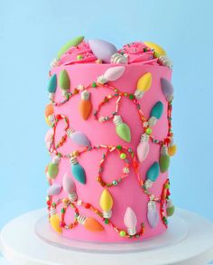 a pink cake with lots of colorful decorations on it