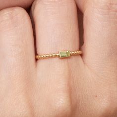 Celebrate the vibrant energy of August with this dainty and enchanting Peridot Ring. The ring showcases a captivating baguette-cut peridot, radiating a lush green hue that evokes a sense of tranquility and renewal. Its dainty setting on a textured gold band, adorned with shimmering beads, adds a touch of playful sophistication.  - Handmade - Solid Gold - Natural Peridot - Bezel Dimension:  5mm x  3mm - Band Width: 1.5mm - Total Carat Weight:  0.12ctw 🛠 Your Sarah Elise piece is handcrafted with care! Ready-to-ship items go out within 3 business days. Made-to-order pieces typically take 7-10 business days to create. If you need something sooner, please contact us - we'll see if we can make it happen! For estimated shipping dates and tracking, check your Etsy account under 'Orders'. 🚐Order Memory Ring, Solid Gold Bracelet, Beautiful Gift Wrapping, Gold Ring Stack, Initial Jewelry, Peridot Ring, Solid Gold Rings, Diamond Eternity, Gold Wedding Rings