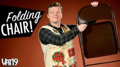 a man holding up a folding chair in front of a red background