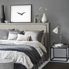 a bedroom with gray walls and white bedding