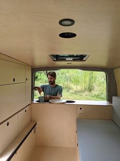 a man sitting in the back of a truck looking at something on the counter top