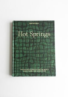 a book with the title hot springs written in white lettering on green alligator skin leather