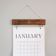 a calendar hanging on a wall with clothes pins