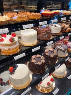 many different types of cakes on display in a bakery