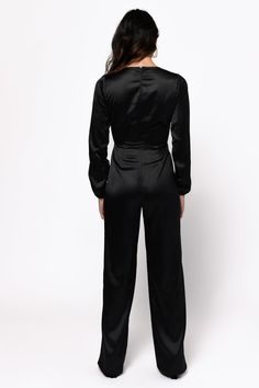 This Satin Jumpsuit Is Looking To Party. The Mila Black Front Tie Satin Jumpsuit Features Long Relaxed Sleeves, V-Neckline, Front Tie, Front Cut Out, And Flared Legs. This Flare Leg Jumpsuit Will Look Great With An Up-Do And Statement Earrings At Your Next Soiree. Satin Jumpsuit, Model Profiles, Strapless Jumpsuit, Front Tie Top, Denim Jumpsuit, Wide Leg Jumpsuit, Black Jumpsuit, Cut Out, Looks Great