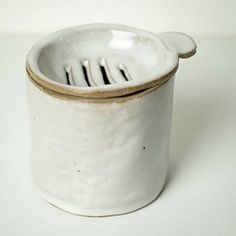 a close up of a white cup with a fork in the middle and a spoon sticking out of it