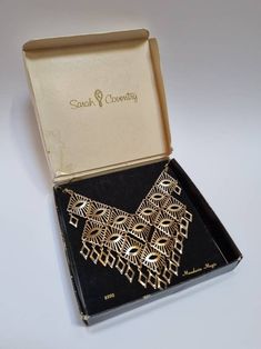 "A stunning statement Sarah Coventry bib necklace, in its original box. Fabulous vintage condition. Signed Sarah Cov on the hangtag. The length is approx 29cm. The bib measures approx 12.5cm x 12.5cm. ------------------ 🏆 About the Designer: Sarah Coventry was founded in 1949, \"for the woman who dares to be different\", and was sold exclusively at home parties, as opposed to in shops. Pieces from the 60s and 70s are especially prized by collectors, because of their intricate detail and use of Metal Bib Necklace For Costume Jewelry Gift, Metal Bib Necklace As Costume Jewelry Gift, Gold Rectangular Necklace For Evening, Rectangular Gold Necklace For Evening, Vintage Rectangular Necklaces For Formal Occasions, Vintage Rectangular Formal Necklaces, Vintage Metal Bib Necklace As Gift, Vintage Metal Bib Necklace For Gift, Vintage Gold Chain Necklace For Party