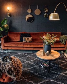 a living room with two couches and a coffee table in front of a brick wall