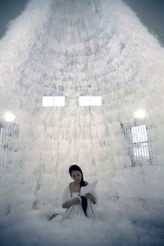 a woman sitting on top of a cloud filled with papers