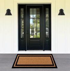 a black front door with two sidelights and a brown rug on the floor in front of it