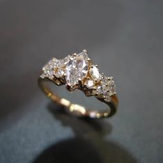 a three stone diamond ring sitting on top of a table