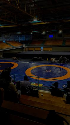 an empty wrestling ring with people sitting in it