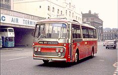 an old red bus is driving down the street