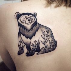 a black and white drawing of a bear on the back of a woman's shoulder