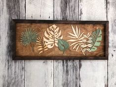 a wooden frame with some cut out leaves on it