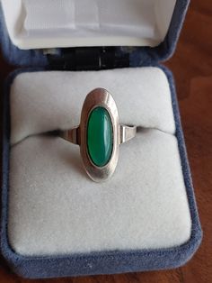 "A beautiful, German Jugendstil style silver Art Deco Chrysoprase ring. Circa 1950s. This item is vintage/antique, there is wear due to age. **The band was snipped to make it adjustable at one point, this could be soldered if desired. Overall good condition, but the last picture shows some imperfections on the underside of the gemstone.**  Jugendstil: (\"Youth Style\") was an artistic movement, particularly in the decorative arts, that was influential primarily in Germany and elsewhere in Europe to a lesser extent from about 1895 until about 1910. It was the German counterpart of Art Nouveau. The members of the movement were reacting against the historicism and neo-classicism of the official art and architecture academies. It took its name from the art journal Jugend, founded by the German Vintage Silver Opal Cabochon Ring, Vintage Green Oval Opal Ring, Vintage Silver Oval Opal Ring, Vintage Sterling Silver Hallmarked Opal Ring, Vintage Silver Opal Ring With Oval Shape, Vintage Silver Turquoise Ring With Polished Finish, Vintage Silver Oval Emerald Ring, Retro Silver Rings For Formal Occasions, Retro Style Silver Rings For Formal Occasions