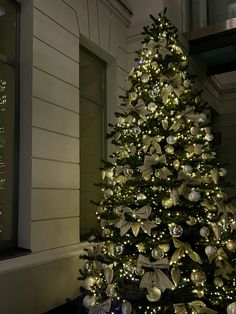 a decorated christmas tree in front of a house