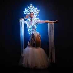 a woman in a white dress with lights on her head and hands behind her back