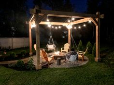 an outdoor patio with lights strung over the top and two chairs on the bottom deck