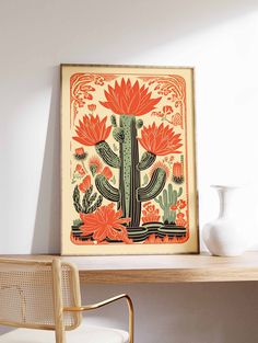 a cactus and flowers print hangs on the wall next to a desk with a chair