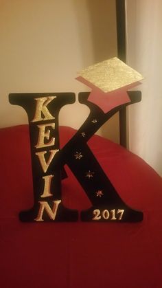 the letters k and n are made out of wood with glitter on top of them