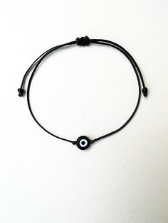 The black evil eye brings good luck,power and protection from envious people. This simple yet beautifull bracelet is made using durable black waxed string and has a glass beed evil eye charm in the middle,and black seed beads at the ends. The diameter of the flat eye bead is 7mm approx. It is adjustable with a sliding knot closure. -It is advisable to use this bracelet on children over 3 years,since it contains small beads... Other evil eye bead bracelets from my shop: https://www.etsy.com/shop/ Black Spiritual Evil Eye Bracelet, Black Spiritual Friendship Bracelets With Evil Eye, Black Spiritual Evil Eye Bracelet For Gift, Spiritual Black Friendship Bracelets With Evil Eye, Black Spiritual Evil Eye Bracelet Gift, Spiritual Black Evil Eye Friendship Bracelets, Black Spiritual Jewelry With Evil Eye, Spiritual Black Evil Eye Bracelet As Gift, Spiritual Black Friendship Bracelet With Evil Eye