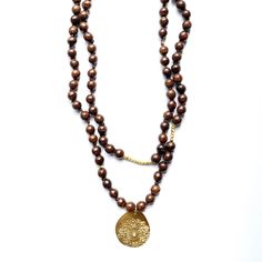 Large, warm brown wooden beads born from the earth. An interpretation of the current color trend, MAS-style. Can be worn long or doubled at the neck for 3 completely different looks. Charm: 24k gold vermeil, about 35mm round with a crystal. Fireworks Design. Necklace: 42" Beads: 8 mm, round, with 22k gold vermeil beads interspersed throughout the necklace. Each piece of MAS Designs jewelry is handcrafted and may vary slightly from the photo on the website. Thats what makes it special and uniquel Fireworks Design, Wood Bead Necklace, Long Beaded Necklace, Warm Brown, Brown Wood, 22k Gold, Bead Necklace, Wooden Beads, Wood Beads