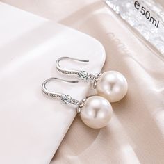 Regally divine, these pearl drop earrings are a tasteful addition to her jewelry box. Created in sterling silver, each beautiful earring showcases a beguiling 12mm white cultured pearl and shimmering white stones. With ease and elegance, these classic pearl drop earrings complete her tailored anytime attire.Width: 12 mmHeight: 30 mmThickness: 12 mmMaterial: 925 SilverPlating Color: Silver Elegant Diamond White Pearl Bridal Earrings, Graceful Pearl Earrings As A Gift, Elegant Pearl White Earrings With Pearl Chain, Elegant Pearl White Earrings With Pearl Drop, Elegant Pearl White Pearl Chain Earrings, Elegant Pearl White Pearl Drop Earrings, White Bridal Earrings With Pearl Charm And Cubic Zirconia, Elegant Diamond White Pearl Earrings For Gift, Elegant Diamond White Pearl Earrings As Gift