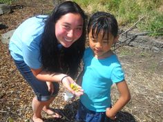 a woman and child standing next to each other on the ground with food in their hands