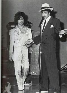 two men standing next to each other in front of microphones