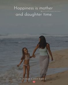 a mother and daughter walking on the beach holding hands with an ocean in the background