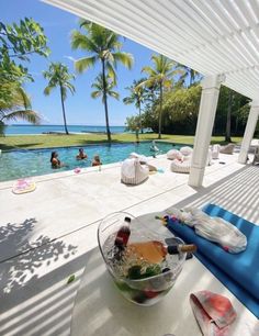 an outdoor pool area with lounge chairs, and a bowl of fruit on the table