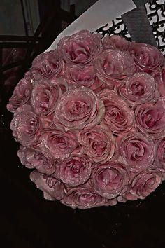 a bouquet of pink roses sitting on top of a table