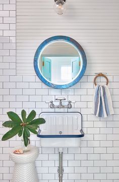 an instagram photo of a bathroom sink with a mirror above it and a plant in the corner