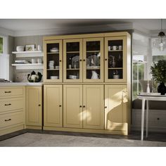 a kitchen with yellow cabinets and white counter tops in front of a dining room table