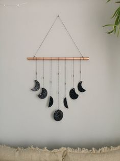 a wind chime hanging from the side of a wall with moon phases on it