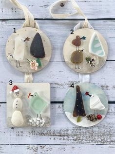 four ceramic ornaments are hanging on a white wooden background, with numbers in the middle