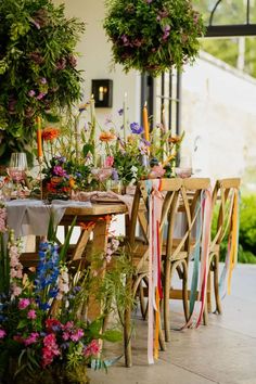 the table is set with flowers and candles for an outdoor dinner or party, along with ribbons tied around it