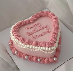 a heart shaped birthday cake with pink frosting and pearls on the edges that says happy birthday