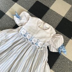 "^ 60's/70's Pale Blue and White Vertical Stripe Puff Short Sleeve Dress. Pale Blue Satin Ribbon Bows are on the Cuffs. Along the Bottom there is White Lace Trim. This dress has a square bib overlay at the neckline with lace floral and satin design, a round neckline, zipper up the back for closure and matching striped fabric belt that ties in the back. There is a ruffle trim skirt layer underneath that hangs longer than the dress. Modern Kids Size: 2T (see specific measurements below) Vintage Si Blue Puff Sleeve Dress For Dress-up, Retro Blue Puff Sleeve Dress, Spring Blue Cotton Vintage Dress, Spring Blue Vintage Cotton Dress, Blue Cotton Vintage Dress With Ruffles, Blue Cotton Retro Vintage Dress, Blue Retro Cotton Vintage Dress, Blue Retro Vintage Cotton Dress, Circle Skirt Dress