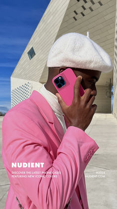 a man in a pink suit is talking on his cell phone while wearing a white hat