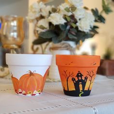 two pumpkin themed cups sitting on top of a table