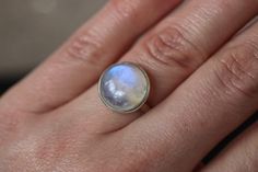 "This unique rainbow moonstone ring is adjustable for US sizes 7, 8 and 9, so you can adjust it via the two smooth ends of the band to fit your perfect size. A stone for \"new beginnings\", Moonstone is a stone of inner growth and strength. It soothes emotional instability and stress, and stabilises the emotions, providing calmness. Moonstone enhances intuition, promotes inspiration, success and good fortune in love and business matters. This ring has been handmade of 925 Sterling Silver in our Adjustable Moonstone Ring With Round Stone, Adjustable Fit Moonstone Ring With Round Stone, Adjustable Cabochon Moonstone Promise Ring, Adjustable Labradorite Moonstone Promise Ring, Adjustable Moonstone Crystal Ring With Cabochon, Iridescent Moonstone Ring In Sterling Silver, Iridescent Sterling Silver Moonstone Ring, Untreated Round Moonstone Ring, Inner Growth