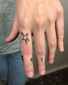 a person with a star tattoo on their ring finger