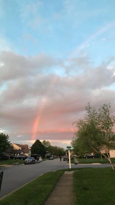 a rainbow in the sky over a neighborhood