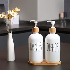 two hand soap dispensers sitting next to each other on a counter top