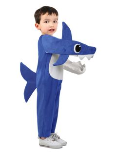 a young boy in a blue shark costume standing up with his hands on his hips